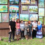Respublikinio tapybos plenero dalyviai prie savo darbų, eksponuojamų ant bendruomenės namų „Strėva“ sienos